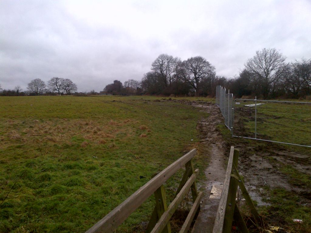 A view of Codnor Common that is still undeveloped, a bridge and stile points towards Ripley
